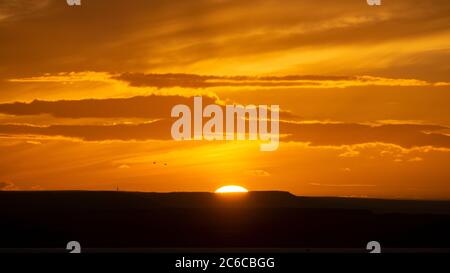 Die Sonnenuntergänge über dem Meer in der Nähe von Thornwick Bay, Flamborough Head, East Yorkshire, Großbritannien Stockfoto