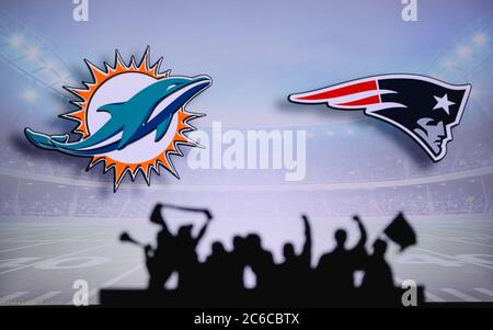 Miami Dolphins gegen New England Patriots. Fans unterstützen NFL Game. Silhouette der Unterstützer, große Leinwand mit zwei Rivalen im Hintergrund. Stockfoto