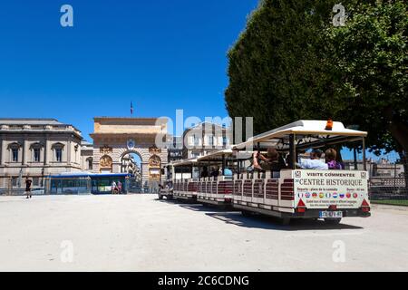 MONTPELLIER, FRANKREICH - 24. Juni 2015: La Promenade du Peyrou. Triumphbogen und Sightseeing-Bus mit Touristen (Le Petit Train De Montpellier) Stockfoto