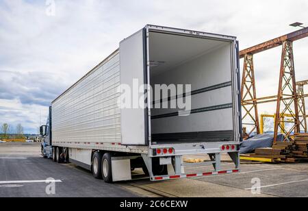 Professionelle Qualität Big Rig blau semi-Truck mit offener Tür leer Auflieger auf Lager Parkplatz am Industriegebiet warten auf die comm Stockfoto