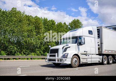 Langstrecke pro Industrieklasse Big Rig weißen Semi-Truck mit Schutzwächter Transport von Fracht im Kühlschrank Semi-Truck fahren auf der Multiline h Stockfoto