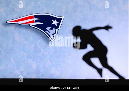 New England Patriots. Silhouette des professionellen amerikanischen Fußballspielers. Logo des NFL-Clubs im Hintergrund, bearbeiten Raum. Stockfoto