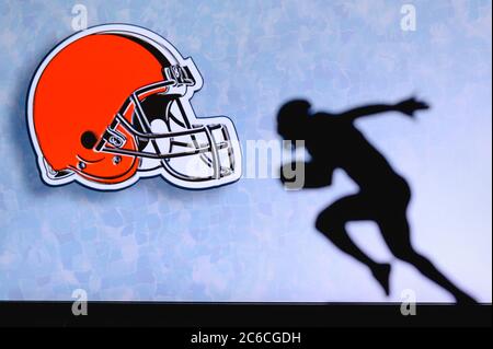 Cleveland Browns. Silhouette des professionellen amerikanischen Fußballspielers. Logo des NFL-Clubs im Hintergrund, bearbeiten Raum. Stockfoto