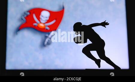 Tampa Bay Buccaneers. Silhouette des professionellen amerikanischen Fußballspielers. Logo des NFL-Clubs im Hintergrund, bearbeiten Raum. Stockfoto