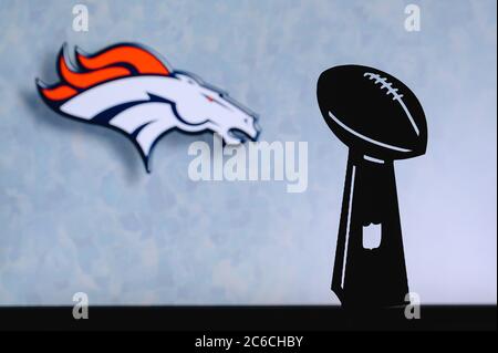 Denver Broncos professioneller amerikanischer Fußballverein, Silhouette der NFL-Trophäe, Logo des Vereins im Hintergrund. Stockfoto