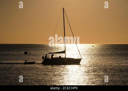 Segelboot Silhouette in der Mitte des Atlantiks während des Sonnenuntergangs an einem Sommertag Stockfoto