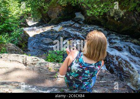 Lady, die ein Bild von einem Wisconsin Fluss mit ihrem Smartphone macht, horizontal Stockfoto