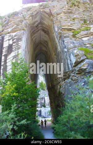 Natürlicher gewölbter Eingang eines ehemaligen Marmorsteinbruchs in den apuanischen alpen des apennins Stockfoto