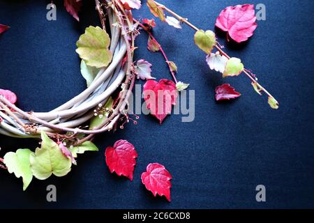 Herbsthintergrund mit leuchtenden Herbstblättern auf schwarz, eine Designvorlage mit einem Platz für Text Herbstkranz mit roten Herbstblättern auf dunklem Hintergrund. au Stockfoto