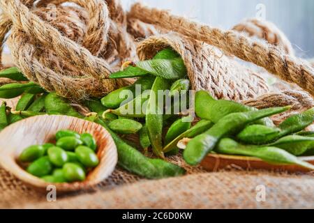 Edamame oder Sojabohnen in einem Holzteller auf einem braunen Sacktuch. Stockfoto