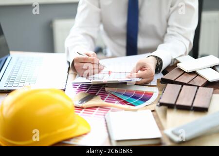 Designer im Büro sitzt am Tisch mit Projekt und einer Farbpalette für die Einrichtung Stockfoto