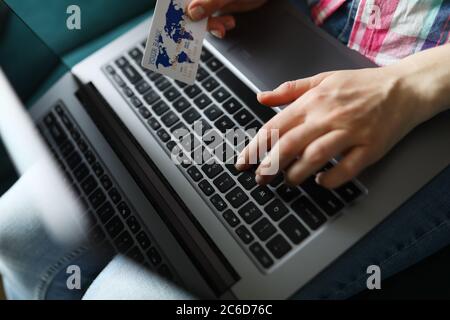 Frau hält Kreditkarte und Typen auf Laptop-Tastatur Stockfoto