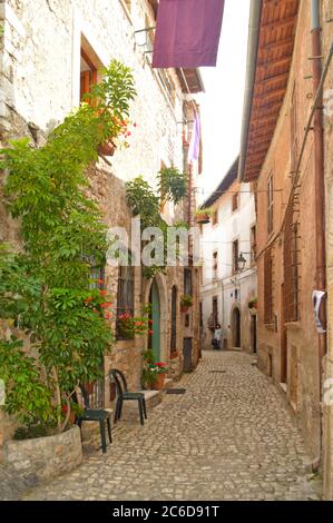 Eine Straße zwischen den mittelalterlichen Mauern der Stadt Sermoneta, Italien. Stockfoto