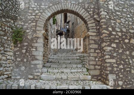 Eine Straße zwischen den mittelalterlichen Mauern der Stadt Sermoneta, Italien. Stockfoto