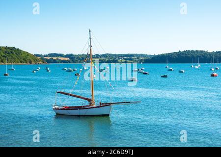 Segelboot und Fischerboote, die ruhiges Wasser der schönen Bucht in Saint-Suliac anlegen. Bretagne Sommer Tourismus Hintergrund. Frankreich Reisekonzept. Stockfoto