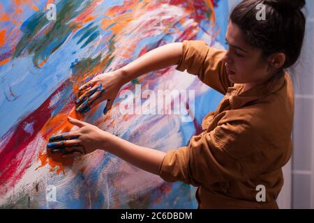 Malerei mit Händen auf großer Leinwand im Kunststudio. Moderne Kunst malen auf Leinwand, kreative, zeitgenössische und erfolgreiche bildende Kunst Künstler Zeichnung Meisterwerk Stockfoto