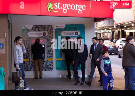 Die Leute nutzen die Aborigine-Geldautomaten der St. George Bank, die die NAIDOC Week in der Filiale an der Ecke Market Street und Pitt Street in Sydney unterstützen. Stockfoto