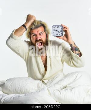 Selbstdisziplin. Erschöpfter Mann, der durch Wecker im Schlafzimmer geweckt wurde. Reifer Mann auf Bett Ausschalten Uhr. Reifer Mann ausschalten Wecker. Digitaler Wecker im Schlafzimmer. Zeit zum Aufwachen. Stockfoto