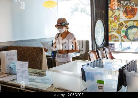 Washington, DC, USA. Juli 2020. Ein Gast mit Gesichtsmaske sieht sich am 2. Juli 2020 ein Menü zum Mitnehmen in einem chinesischen Restaurant in Houston, Texas, USA, an. Kredit: Lie Ma/Xinhua/Alamy Live Nachrichten Stockfoto