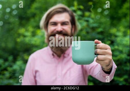 Morgeninspiration. Fühlen Sie echtes Glück. Voller Energie. Heißer Tee in der Tasse. Zeit für das Mittagessen. Kleine Kaffeepause. Bärtige Mann entspannen im Freien. Glücklicher Mann trinken frischen Morgenkaffee. Guten Morgen für Sie. Stockfoto