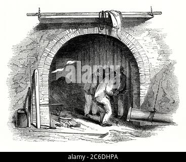 Eine alte Gravur, die Arbeiter in einer Gasfabrik oder in einer Gasfabrik zeigt, hier das Gas anmacht – eine Illustration aus dem frühen 19. Jahrhundert. Kohlegas wurde in den 1790er Jahren von dem schottischen Erfinder William Murdoch nach Großbritannien eingeführt. Frühe Gaswerke wurden in der industriellen Revolution für Fabriken und ab etwa 1805 als Lichtquelle gebaut. Frühe Gaswerke waren in der Regel neben einem Fluss oder Kanal, so dass Kohle konnte in durch Lastkahn gebracht werden. Später verlagerte sich der Verkehr auf die Schiene und die Straße. Stockfoto