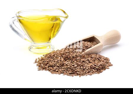 Rohe Leinsamen in Holzlöffel und Leinsamenöl in Glas Soße Boot isoliert auf weißem Hintergrund. Volle Schärfentiefe mit Beschneidungspfad. Stockfoto