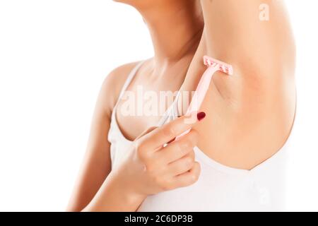 Frau rasiert ihre Achselhöhlen auf weißem Hintergrund Stockfoto