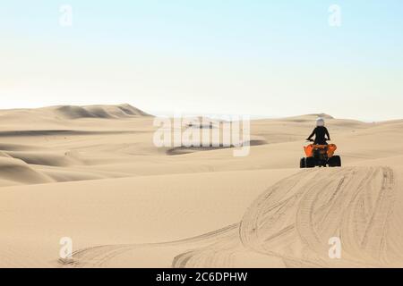 Quad-Fahrende - ein glücklicher Biker in Sandwüstendünen, Afrika, Namibia, Namib, Walvis Bay, Swakopmund. Stockfoto