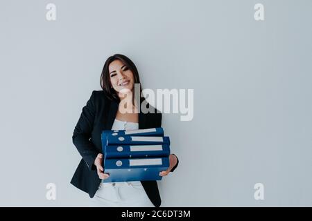 Schöne Brünette Frau in Business-Kleidung mit Ordnern für Papiere im Büro Stockfoto