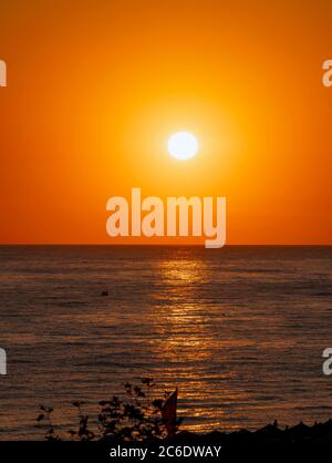 Große Sonne über Meer, roter Himmel Stockfoto