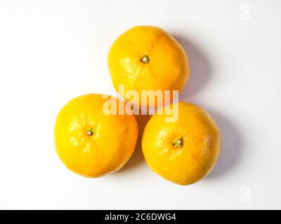 Drei Satsumas in einem Dreieck auf weißem Hintergrund isoliert angeordnet Stockfoto