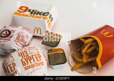 Lviv / Ukraine - April 2020: Ungesunde Ernährung zu Hause während der Isolierung des Coronavirus-Ausbruchs. McDonalds Essen zum Mitnehmen auf einem Tisch. Ukrainische Version Stockfoto