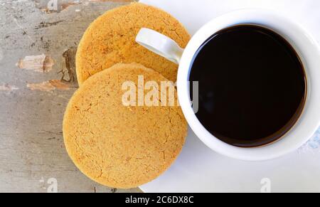 Kuchen und Tasse heißen Kaffee auf altem Holztisch. Draufsicht Stockfoto