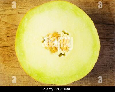 Eine halbe frische galia Melone mit Samen auf einem Holzbrett Stockfoto