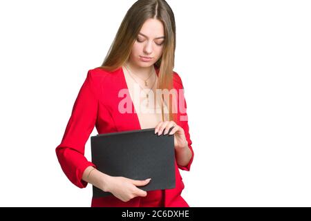 Eine junge Geschäftsfrau in einem roten Anzug einen Hintergrund isoliert in weiß, hält einen Büroordner Stockfoto