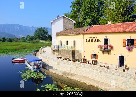 VIRPAZAR, MONTENEGRO - 8. AUG 2009: Skadar-See. Leere Kaffeeterrasse mit Tischen und Stühlen in der Altstadt von Virpazar an sonnigen Tagen. Stockfoto