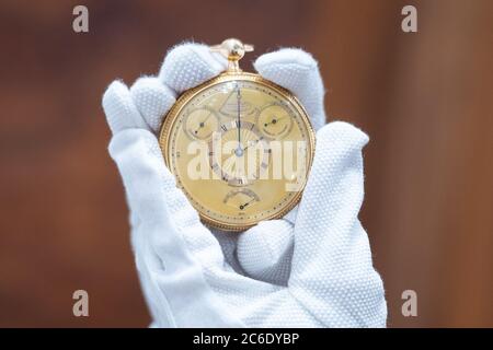 Ein Mitarbeiter von Sotheby's hält die Tourbillon-Uhr von König George III., die vor dem Verkauf durch das Auktionshaus bei Sotheby's im Zentrum von London während der Auktion Collection of a Connoisseur am 4. Juli zu sehen ist. Stockfoto