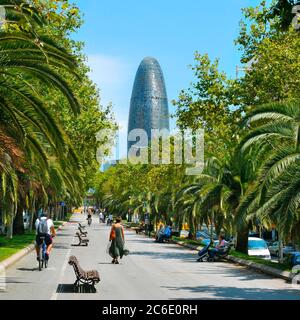 BARCELONA, SPANIEN - 14. JULI: Menschen, die am 14. Juli 2014 in Barcelona, Spanien, in der Avinguda Diagonal mit dem Torre Agbar im Hintergrund spazieren gehen. Diese 38-s Stockfoto