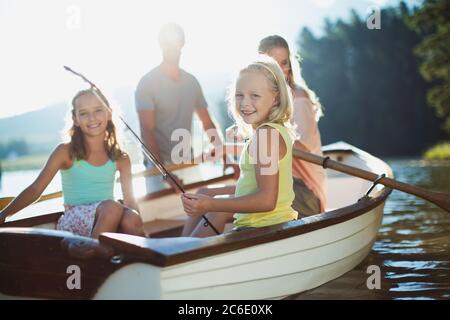 Lächelnde Familie im Ruderboot auf dem See Stockfoto