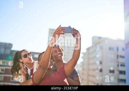 Junge Freunde machen Selfie mit dem Smartphone auf dem sonnigen städtischen Dach Stockfoto