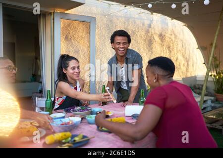 Glückliche junge Freunde mit Smartphone essen Mittagessen auf der Terrasse Tisch Stockfoto