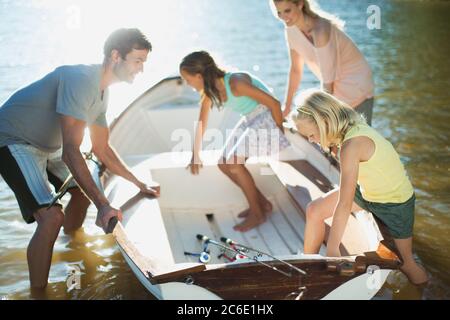 Familie, die in Ruderboot mit Angelruten auf See Stockfoto