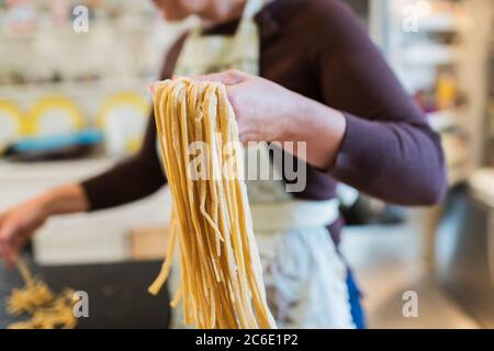 Frau macht frische hausgemachte Pasta in der Küche Stockfoto