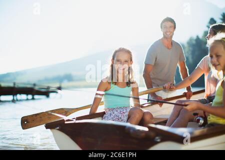 Lächelnde Familie im Ruderboot auf dem See Stockfoto