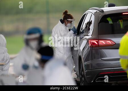 Fahren Sie durch COVID-19-Tests auf dem Parkplatz von Salford Sharks. Die Tester wechseln die PSA nach jedem Test am 29. April 2020 in Salford, Manchester, Nordwestengland Stockfoto