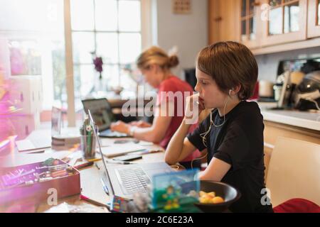 Fokussierter Junge Heimschooling am Laptop in der Küche Stockfoto