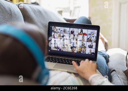 Frau Video chatten mit Freunden auf Laptop-Bildschirm vom Sofa Stockfoto