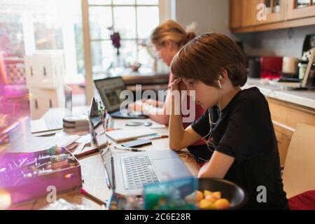 Fokussierter Junge Heimschooling am Laptop in der Küche Stockfoto