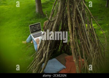 Frau Videokonferenzen mit Freunden auf Laptop-Bildschirm bei Tipi Stockfoto