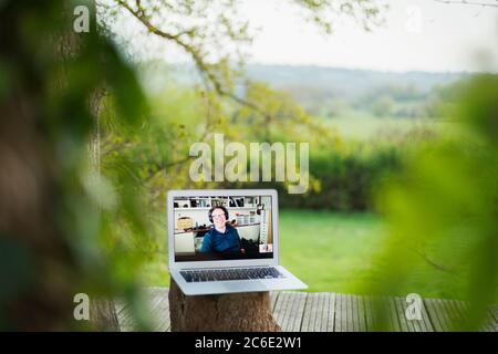 Kollegen chatten auf dem Laptop-Bildschirm auf dem Balkon Stockfoto